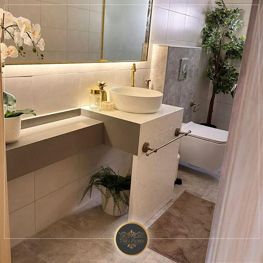 حمام فاخر بالرخام البيج واللمسات الذهبية